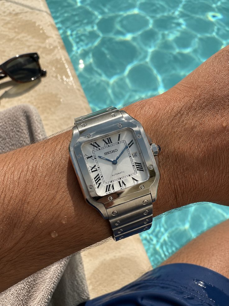 Santos cadran blanc romain porté au bord d'une piscine